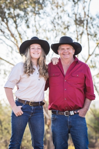 Teenage girl and grandfather with arms around each other on farm in drought - Australian Stock Image