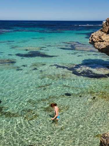 Teenage girl wading in the ocean - Australian Stock Image