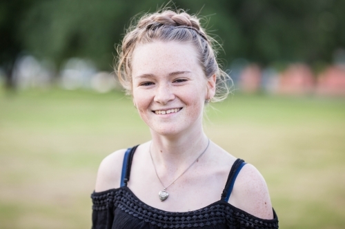 Teenage girl wearing necklace smiling - Australian Stock Image