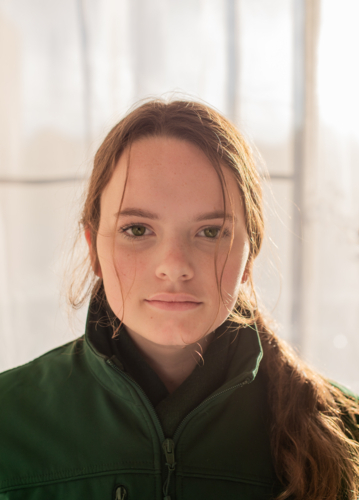 Teenage girl with long hair in winter clothes staring in portrait - Australian Stock Image