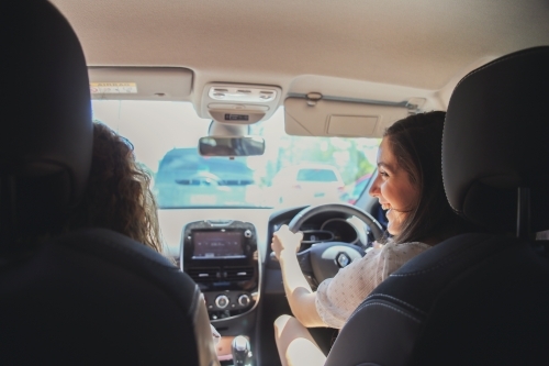 young adult girls driving and chatting in the car - Australian Stock Image