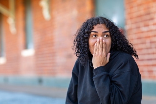 teenager being surprised with hand up to face - Australian Stock Image