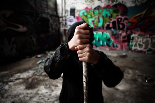 Teenager holding pipe in a pose of strength and defiance