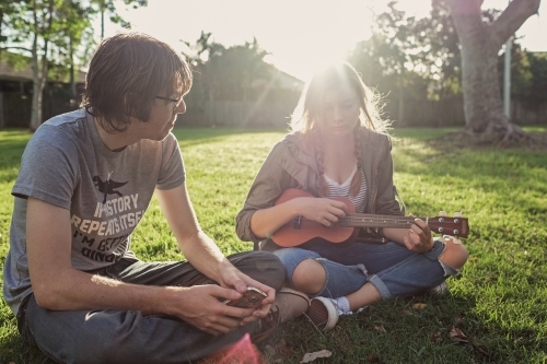 Teenagers playing ukulele in the park - Australian Stock Image