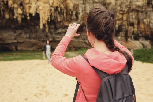 Teenagers using mobile taking pictures - Australian Stock Image