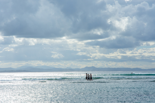 Teenagers walking in water at Byron Bay - Australian Stock Image