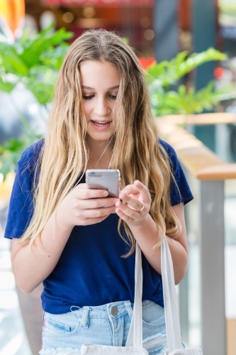 teens at the mall, using phone - Australian Stock Image
