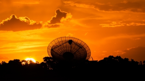 Telescopic Dish against a red fiery sunset sky - Australian Stock Image