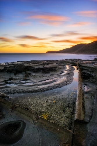 Textured, rocky coastline at sunset