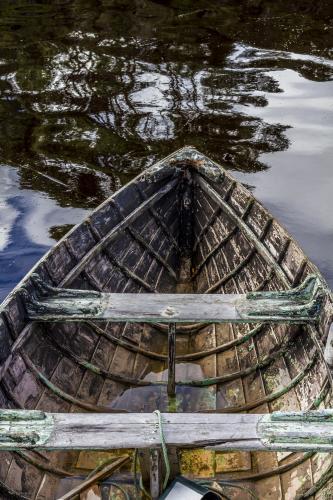The bow of an old wooden boat in the water. - Australian Stock Image