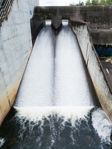 The Enoggera Reservoir, with flowing spillway, in the Brisbane suburb of The Gap - Australian Stock Image