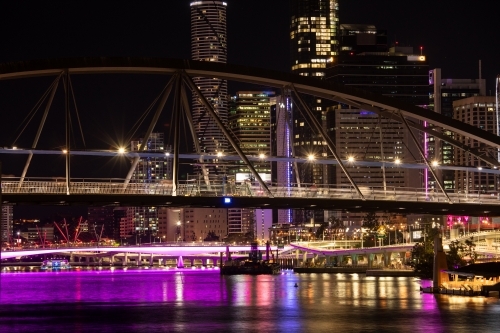 The Goodwill Bridge and Brisbane city at night with light reflecting over the water