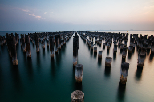 The historic Princes Pier featuring many disused pylons on a hot summer's day - Australian Stock Image