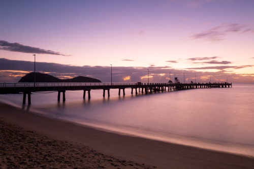The iconic Palm Cove jetty and boat ramp at sunrise on a winter's morning in Queensland, Australia - Australian Stock Image
