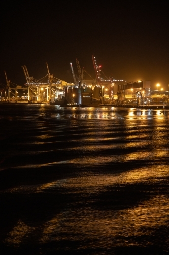 The industrial lighting emitted from The Port of Brisbane operating at night. - Australian Stock Image