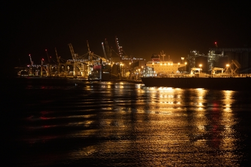 The industrial lighting emitted from The Port of Brisbane operating at night. - Australian Stock Image