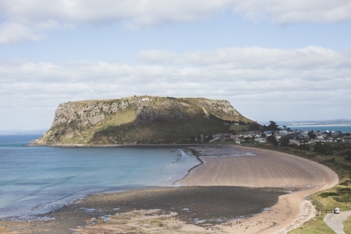 The Nut, Stanley in the background with clouds and blue sky and the beach in the foreground