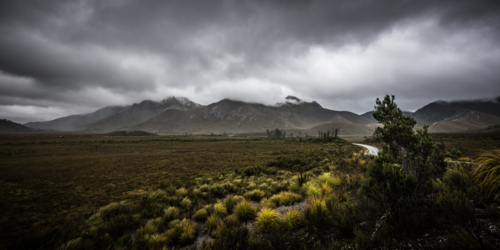 The picturesque Gordon River Rd at the Sentinel range of mountains near Bitumen Bones Sculpture - Australian Stock Image