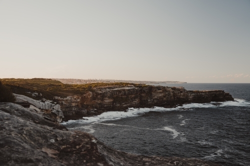 The rocky cliffs of Magic Point on the coastal walk at sunset.