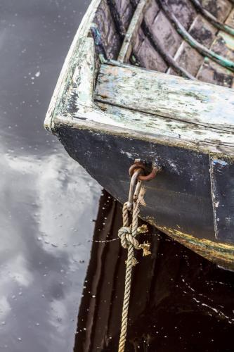 The stern of an old wooden boat moored. - Australian Stock Image