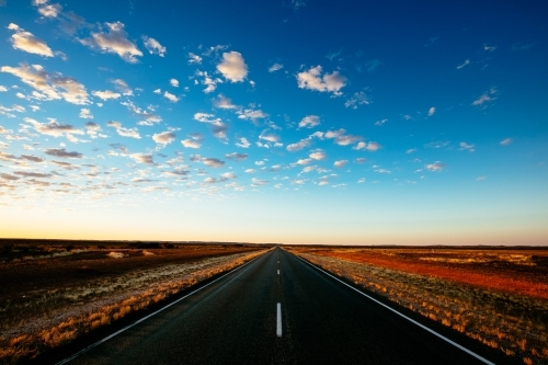 The Stuart Highway disappears into the flat horizon in central Australia. - Australian Stock Image