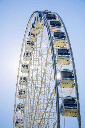 The top half of a ferris wheel backlit against the sun - Australian Stock Image
