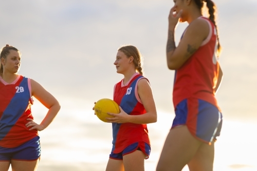 Three female football players talking  after a game - Australian Stock Image