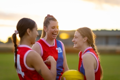 Three female  football players talking  and laughing on the field - Australian Stock Image