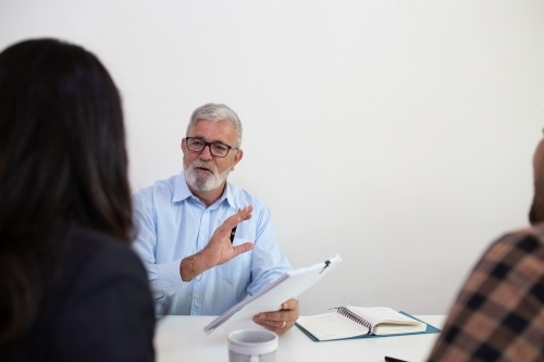 Three people sitting collaborating in an office - Australian Stock Image