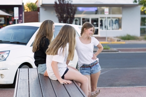 Three teenage girls hanging out in the street