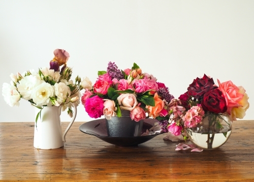 Three vases of fresh farm roses on display