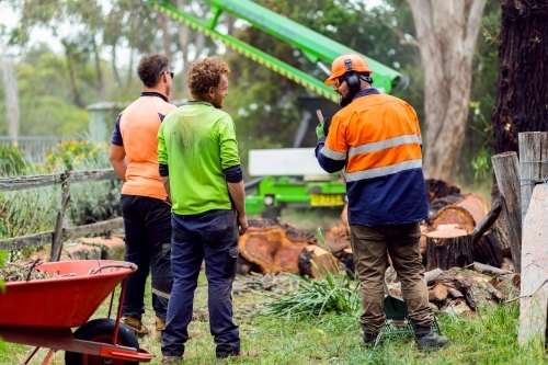 Three workmen on a short break, chatting and laughing together - Australian Stock Image