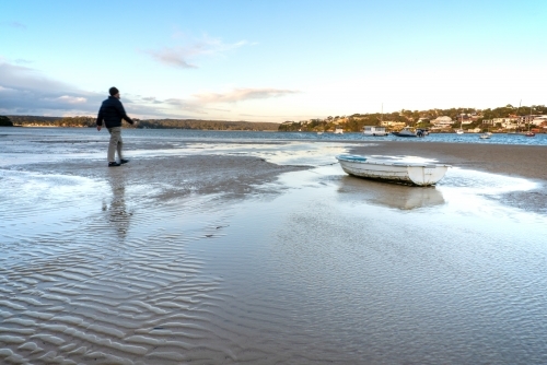 Tidal flats with small stranded boat at Gunnamatta Bay - Australian Stock Image