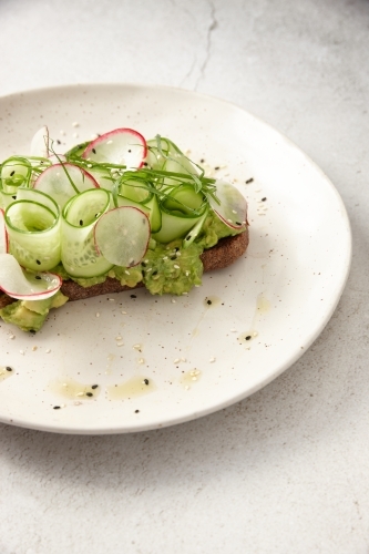 Toast with thin sliced cucumbers and scallions on top - Australian Stock Image