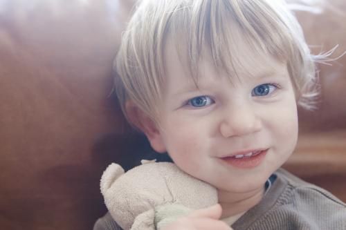 Toddler boy hugging security teddy - Australian Stock Image