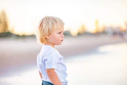 Toddler boy playing in the waves on the beach on the Gold Coast, Queensland Australia - Australian Stock Image