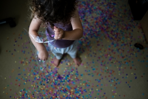 Toddler making mess with confetti