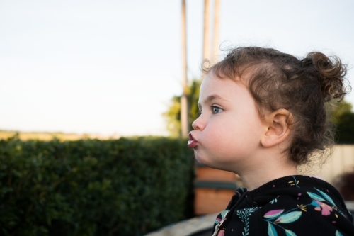 Toddler pulling a silly face outdoors