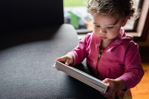 Toddler reading book - Australian Stock Image