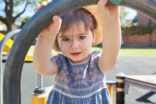 Toddler wearing hat in park playground - Australian Stock Image