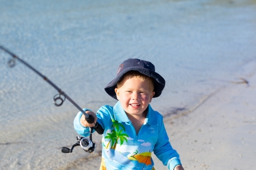 toddler with fishing rod at the waters edge - Australian Stock Image