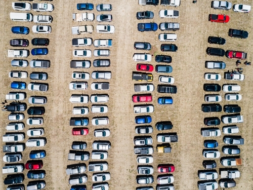 Top down aerial photo of cars in overflow parking in paddock during sport event - Australian Stock Image