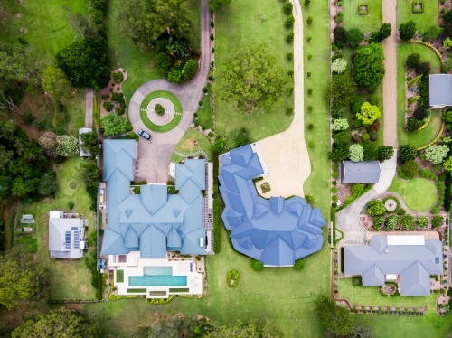Top down aerial view of luxury homes beside small original house - Australian Stock Image