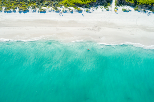 Top down drone view over brilliant teal ocean with white sandy beach - Australian Stock Image