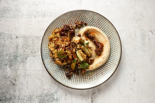 Top down view of a plate of Mediterranean food - vegetables with hummus - Australian Stock Image