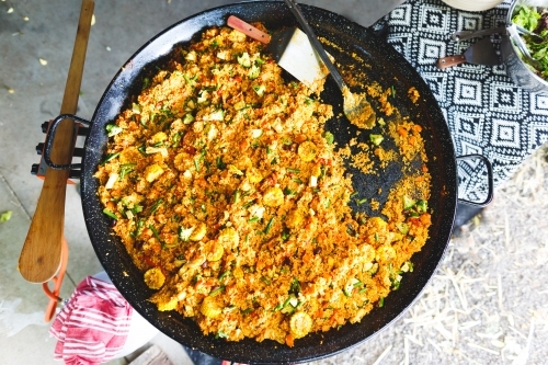 Top down view of paella cooking in a large pan