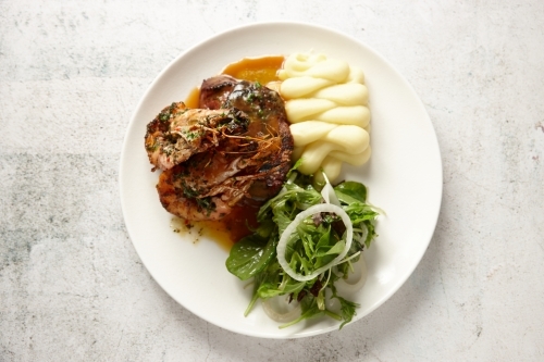 Top down view of Surf and Turf - a steak and grilled prawns served with salad and mash - Australian Stock Image