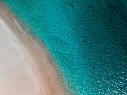 top shot of a white sand beach on a sunny day
