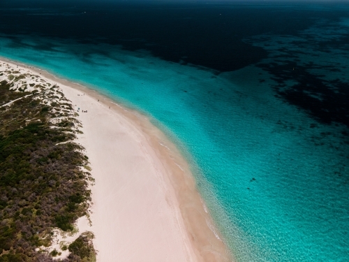 top shot of a white sand beach with grass and bushes on a sunny day - Australian Stock Image