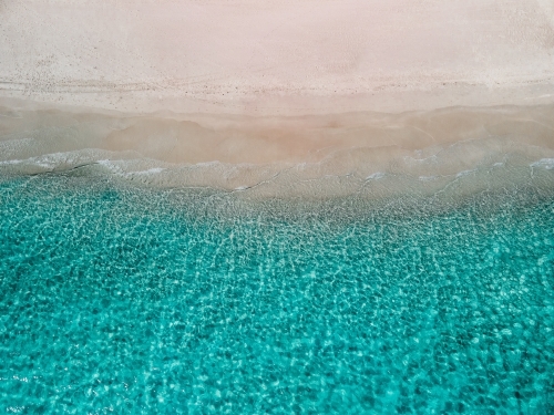 top shot of a white sand beach with small waves on a sunny day - Australian Stock Image